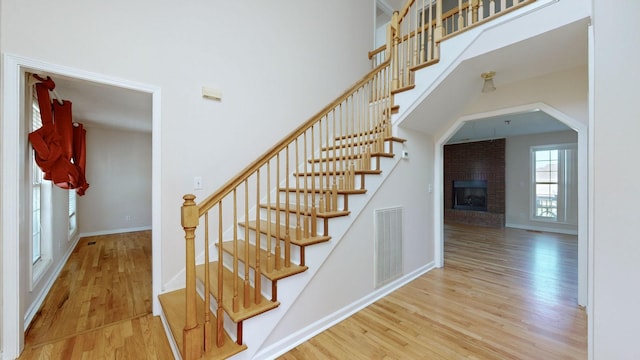 stairs featuring a fireplace and hardwood / wood-style floors