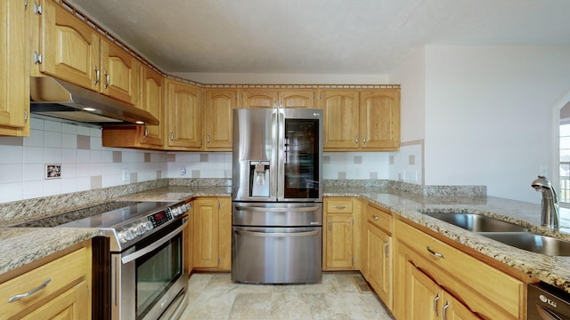 kitchen featuring stainless steel appliances, light stone counters, and sink