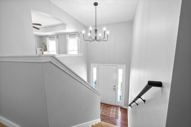 entryway with ceiling fan with notable chandelier and hardwood / wood-style flooring