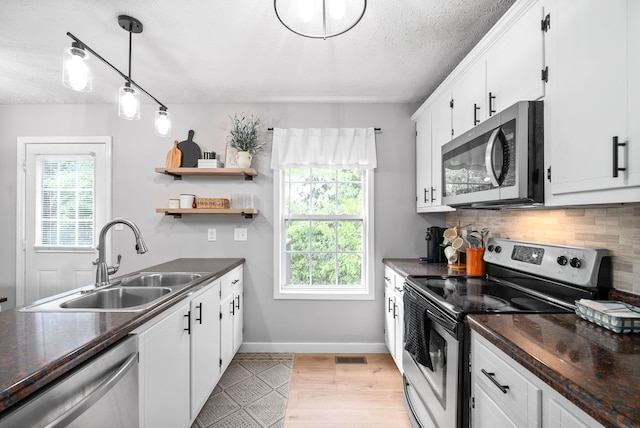 kitchen featuring white cabinets, appliances with stainless steel finishes, and sink