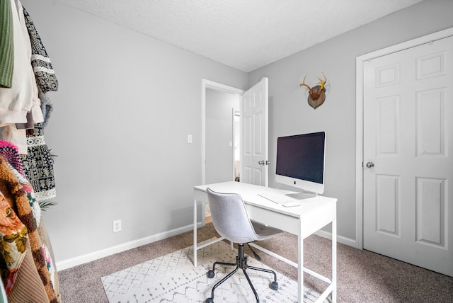 carpeted home office featuring a textured ceiling