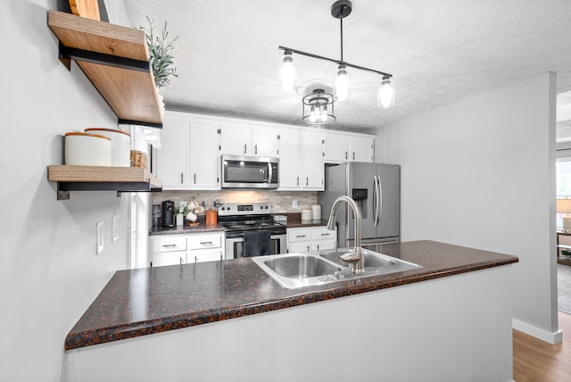 kitchen featuring white cabinets, sink, light hardwood / wood-style flooring, a textured ceiling, and stainless steel appliances