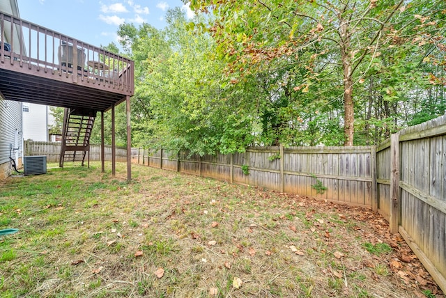 view of yard with central AC and a deck