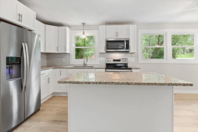 kitchen featuring white cabinets, a wealth of natural light, a center island, and appliances with stainless steel finishes