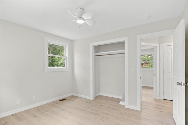 unfurnished bedroom with multiple windows, ceiling fan, and light wood-type flooring