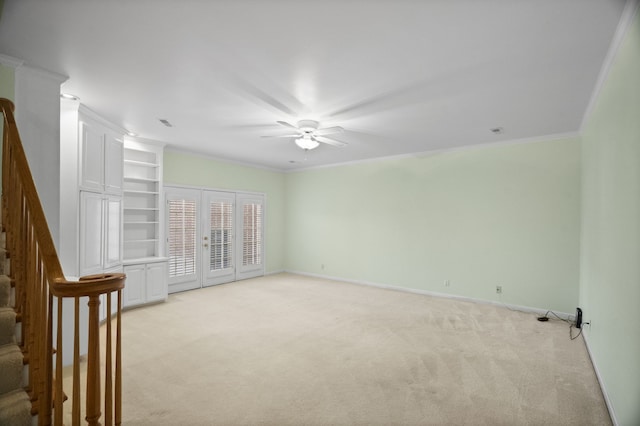 carpeted empty room with ceiling fan, french doors, and ornamental molding