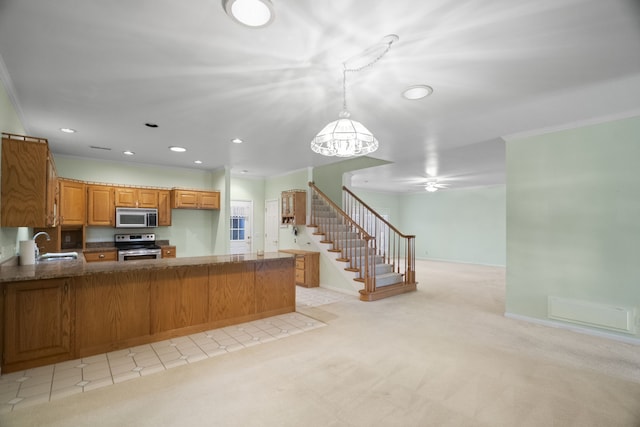 kitchen with sink, stainless steel appliances, kitchen peninsula, light colored carpet, and decorative light fixtures