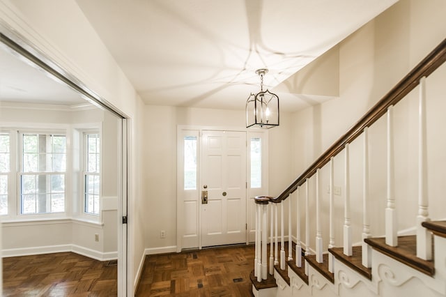 foyer with an inviting chandelier, baseboards, stairway, and a wealth of natural light