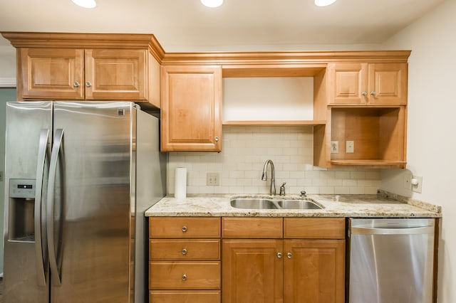 kitchen featuring light stone counters, open shelves, stainless steel appliances, decorative backsplash, and a sink