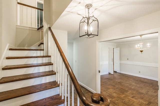 staircase with a chandelier, ornamental molding, and baseboards