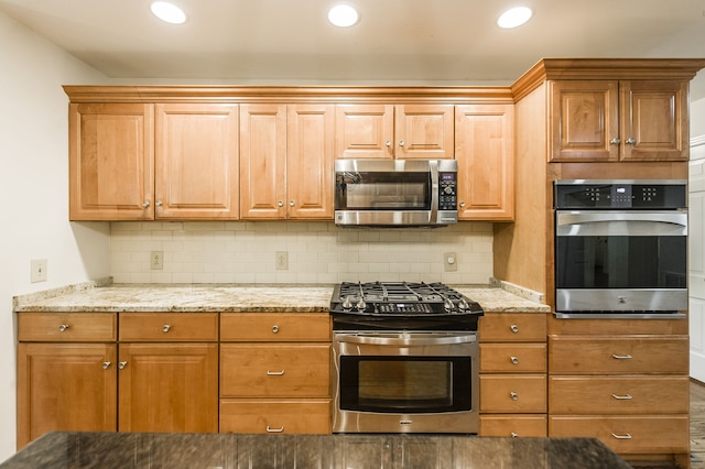 kitchen featuring appliances with stainless steel finishes, recessed lighting, backsplash, and light stone countertops