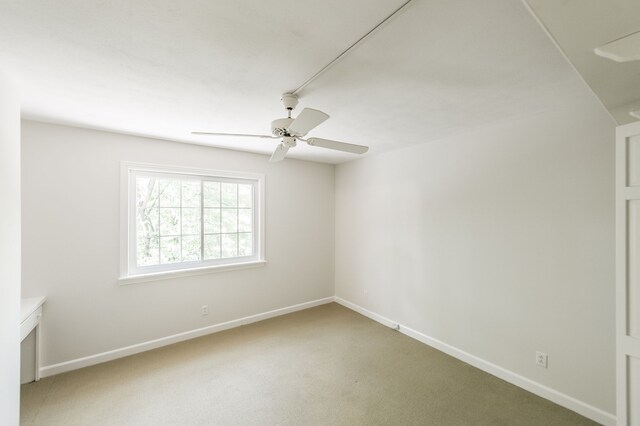 spare room featuring ceiling fan, carpet floors, and baseboards