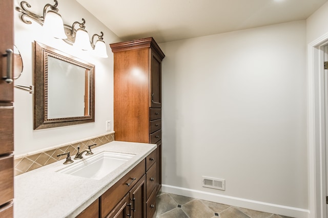 bathroom featuring baseboards, vanity, visible vents, and decorative backsplash