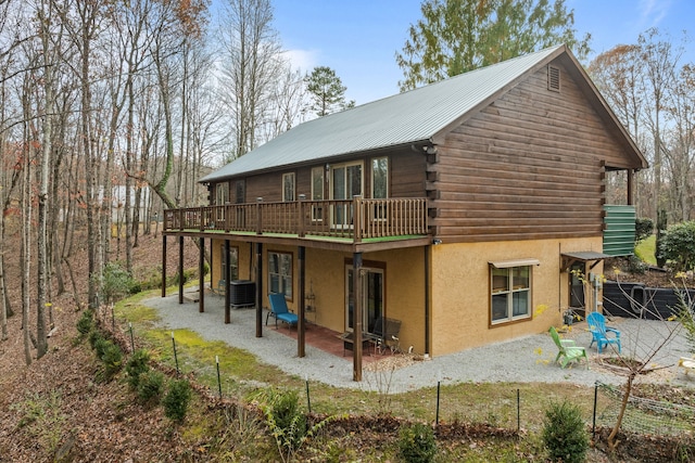 rear view of property featuring cooling unit, a patio area, and a wooden deck