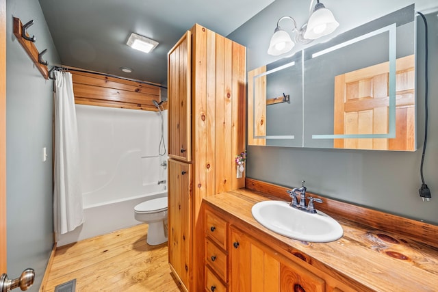 full bathroom featuring vanity, shower / tub combo with curtain, wood-type flooring, a chandelier, and toilet