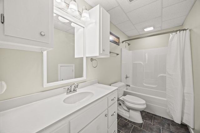 full bathroom featuring tile patterned floors, toilet, a paneled ceiling, shower / bath combo with shower curtain, and vanity