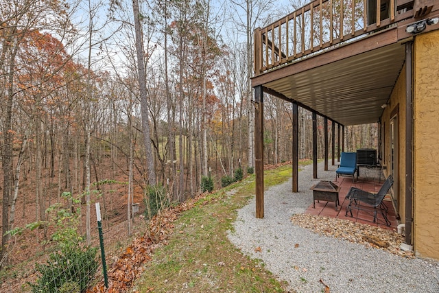 view of yard with cooling unit, a patio area, and a wooden deck