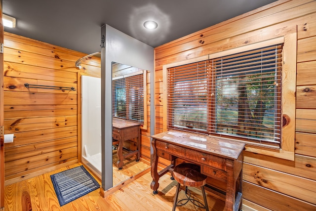 bathroom with hardwood / wood-style flooring and wood walls