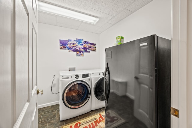 washroom featuring independent washer and dryer and dark tile patterned flooring