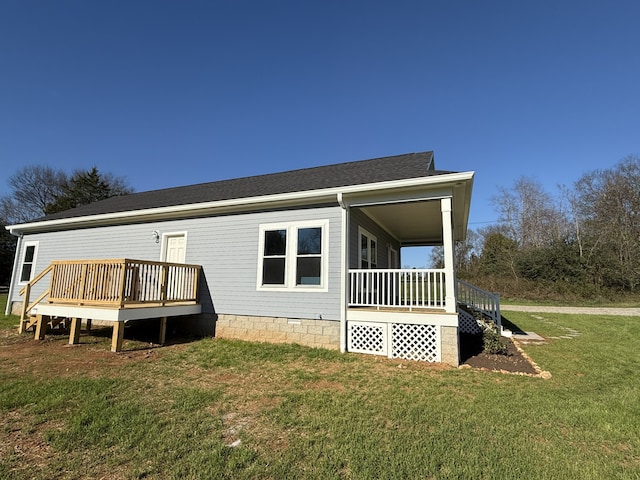 back of house featuring a porch, a yard, and a wooden deck