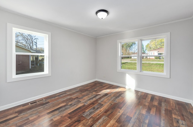 empty room featuring crown molding, plenty of natural light, and dark wood-type flooring