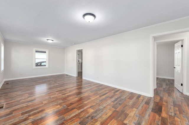 empty room featuring crown molding and dark wood-type flooring