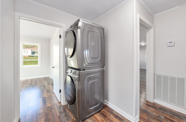 laundry area featuring dark hardwood / wood-style flooring, crown molding, and stacked washer and clothes dryer