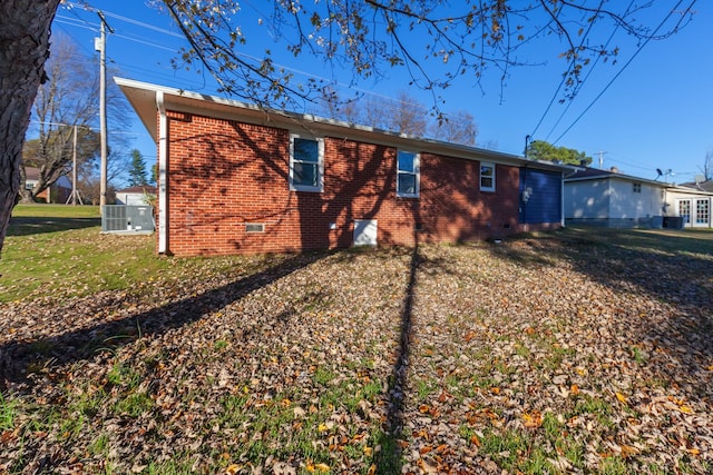 exterior space with central air condition unit and a yard