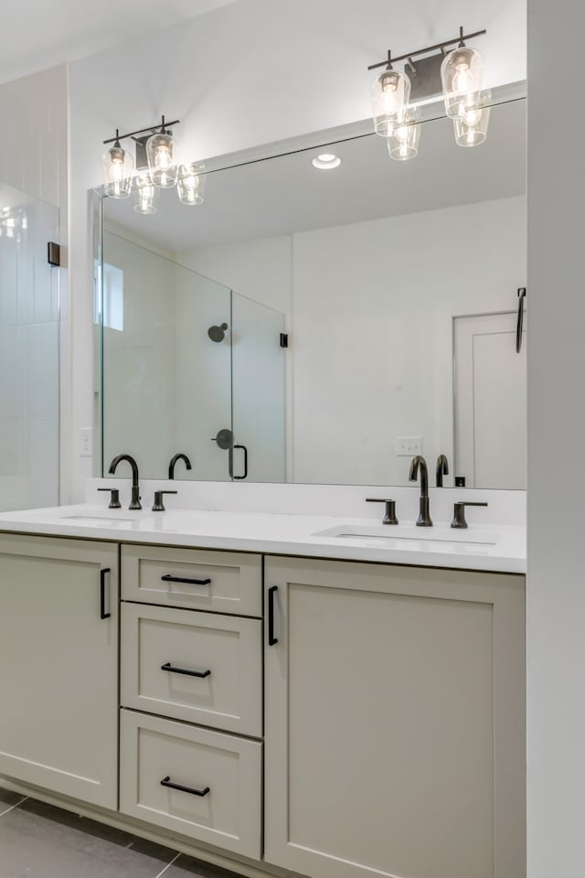 bathroom featuring a shower with door and vanity