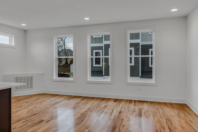 spare room with light hardwood / wood-style floors and a wealth of natural light