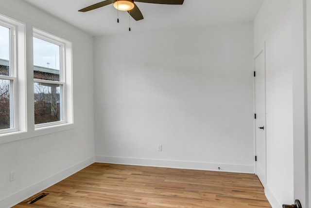 empty room with ceiling fan, plenty of natural light, and light hardwood / wood-style floors