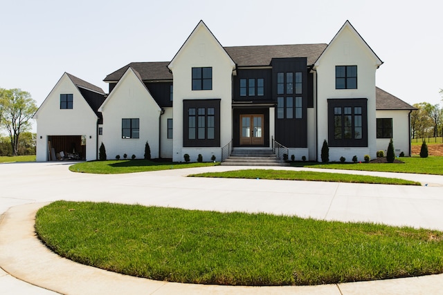 modern farmhouse featuring french doors, a garage, and a front lawn