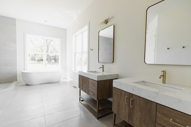 bathroom with tile patterned floors, a bathing tub, and vanity