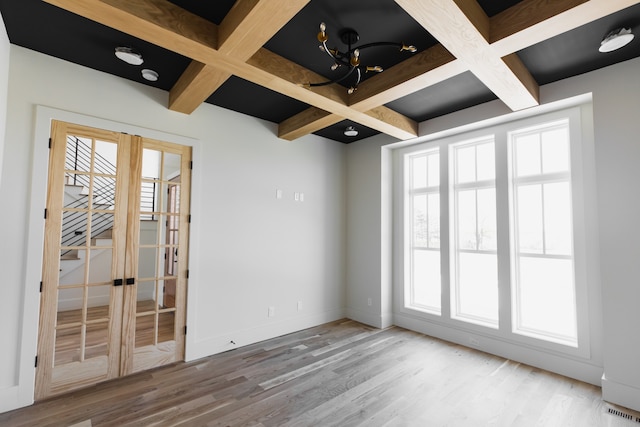 spare room with beamed ceiling, hardwood / wood-style floors, and coffered ceiling