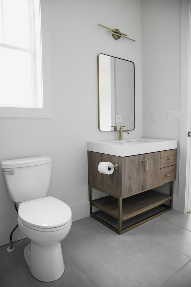 bathroom with tile patterned flooring, vanity, and toilet