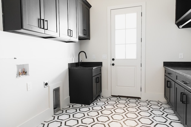 washroom featuring hookup for a washing machine, sink, cabinets, and hookup for an electric dryer