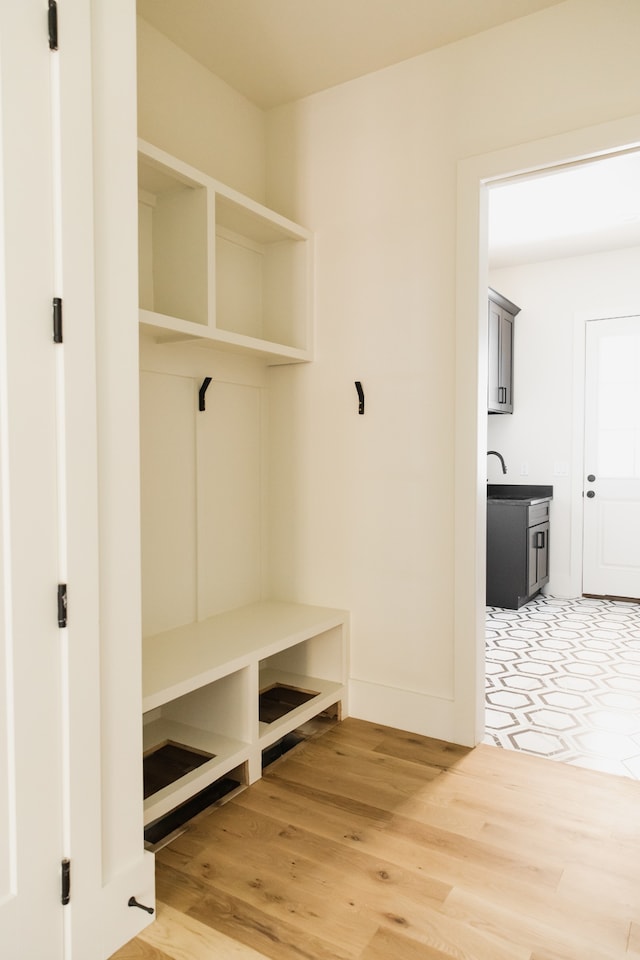 mudroom with hardwood / wood-style flooring and sink