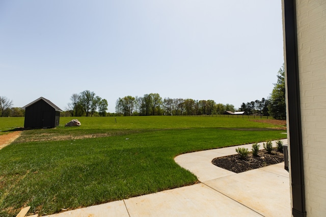 view of yard featuring a rural view and a storage shed