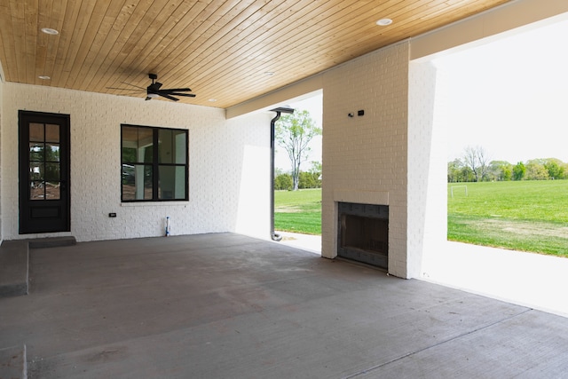 view of patio with ceiling fan and an outdoor brick fireplace