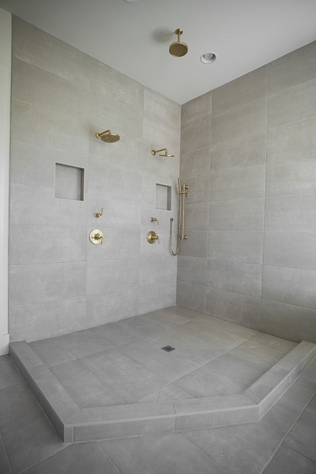 bathroom with tile patterned flooring and tiled shower