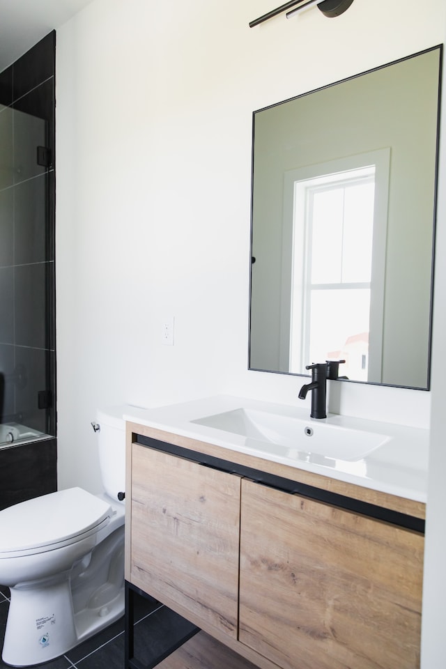 full bathroom featuring vanity, tiled shower / bath combo, and toilet