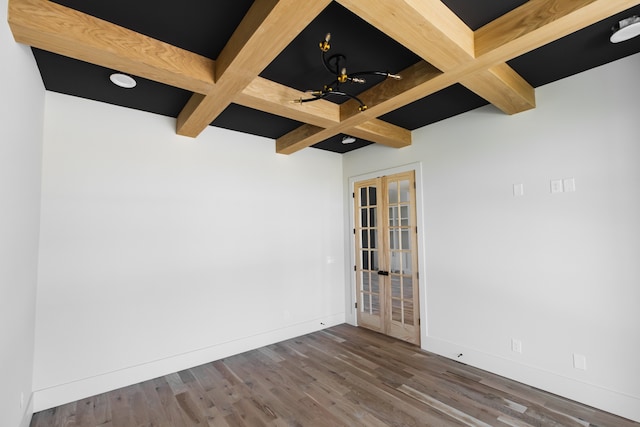 unfurnished room featuring beamed ceiling, dark hardwood / wood-style flooring, coffered ceiling, and french doors