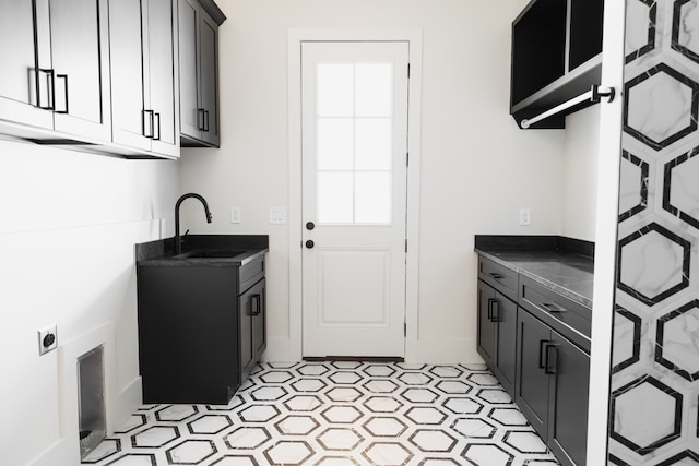 laundry area featuring cabinets, electric dryer hookup, and sink