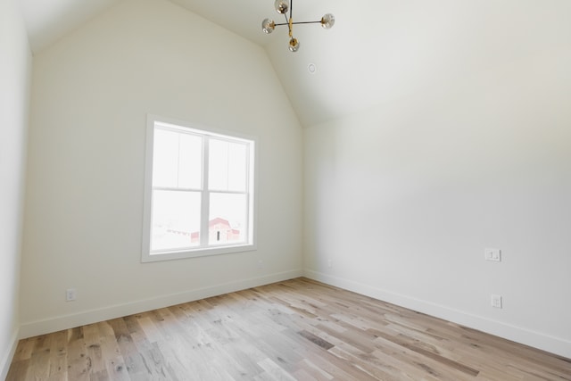 interior space with vaulted ceiling, an inviting chandelier, and light hardwood / wood-style flooring