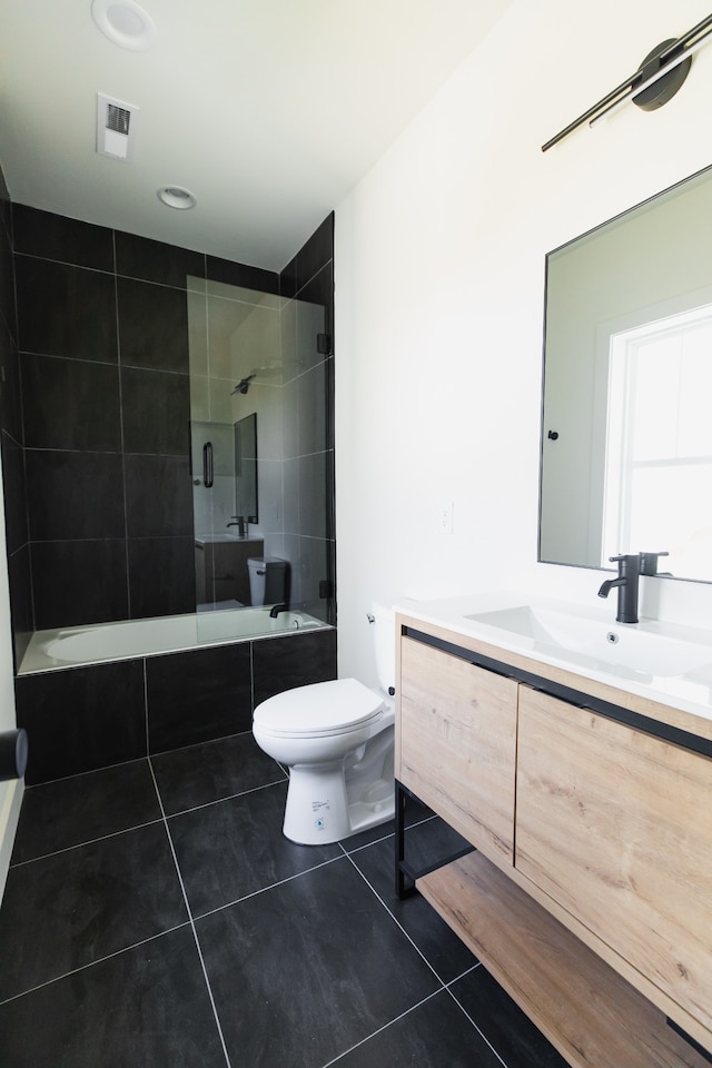 full bathroom featuring tile patterned flooring, vanity, toilet, and tiled shower / bath