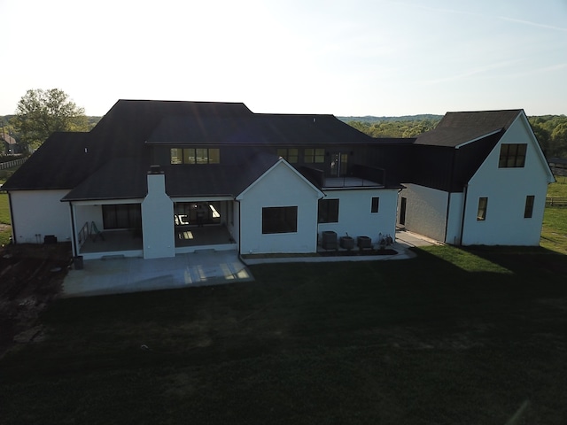 back of house with a lawn, a balcony, and a patio