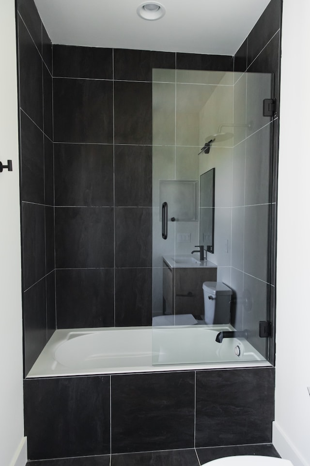 bathroom with tiled shower / bath combo and toilet