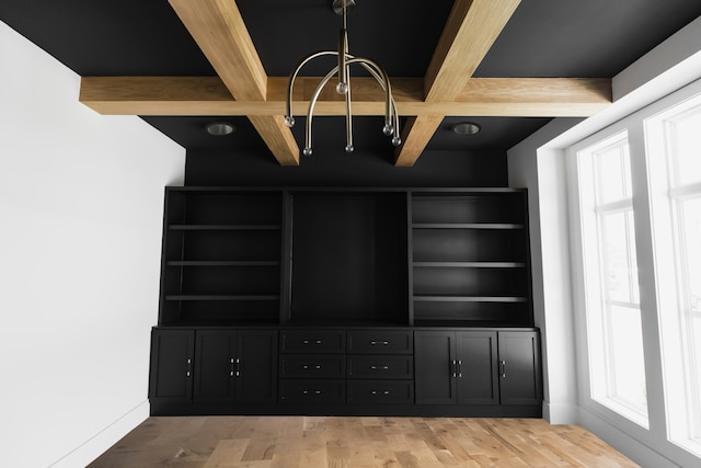 interior space featuring beamed ceiling, hardwood / wood-style flooring, a chandelier, and coffered ceiling