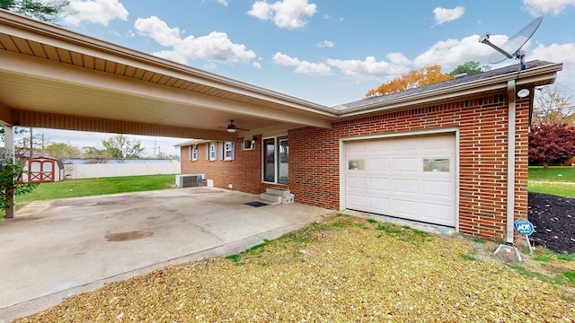 garage featuring central air condition unit and a yard