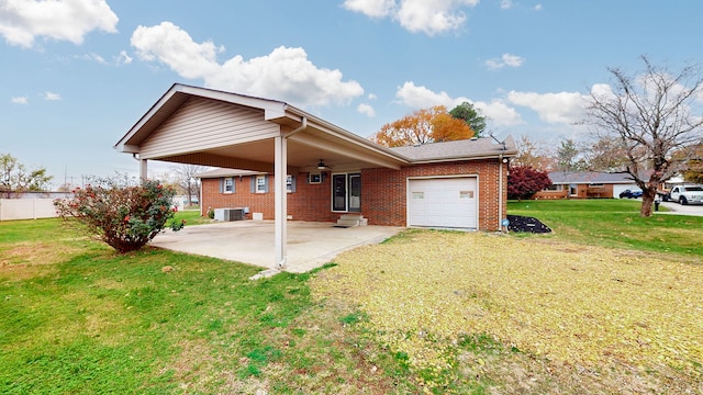 rear view of property with ceiling fan, a yard, central AC unit, and a garage